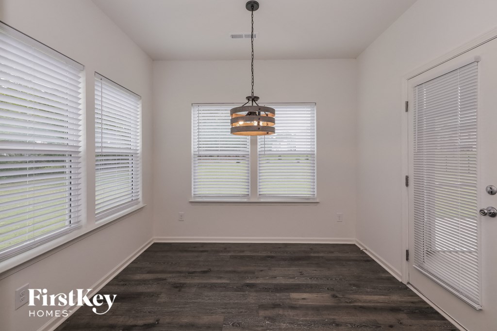 A room with wooden floors and a chandelier hanging from the ceiling.