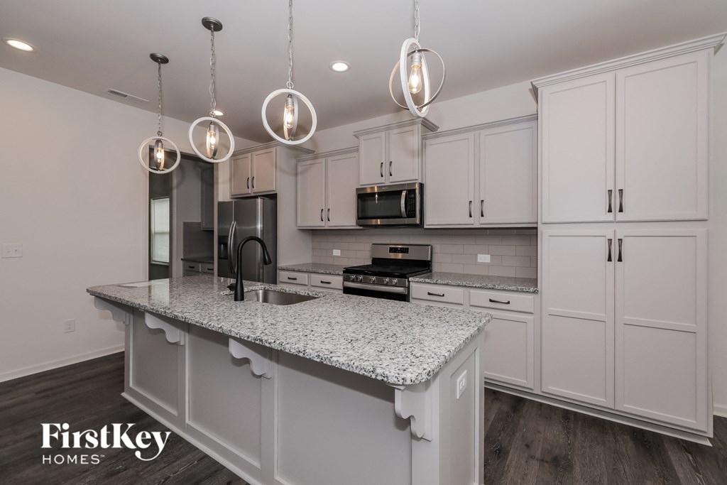 A kitchen with a granite countertop and white cabinets.
