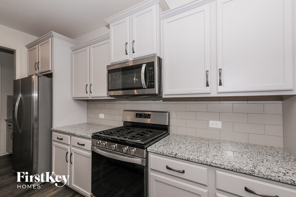 A kitchen with a stove top oven and a microwave above it.
