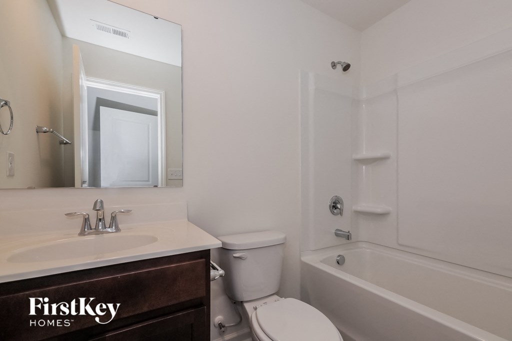 A white bathroom with a FirstKey Homes logo on the vanity.