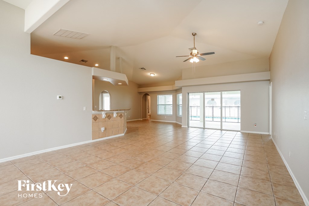 A spacious room with tile flooring and a ceiling fan is available for rent.