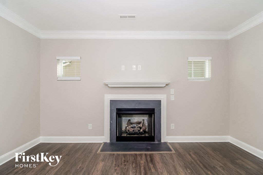 the living room of a home with a fireplace and wooden floors