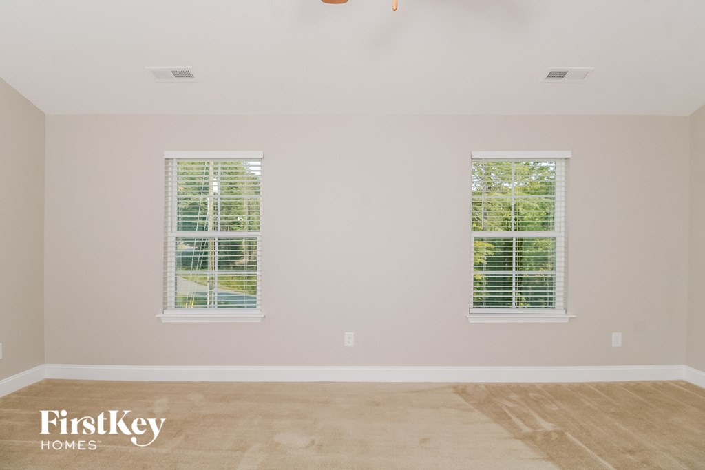 a living room with two windows and a wooden floor