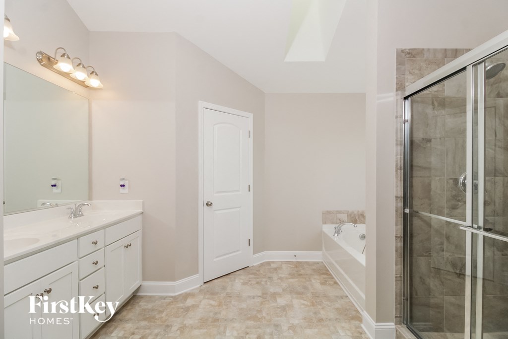 the master bathroom has a large shower and two sinks