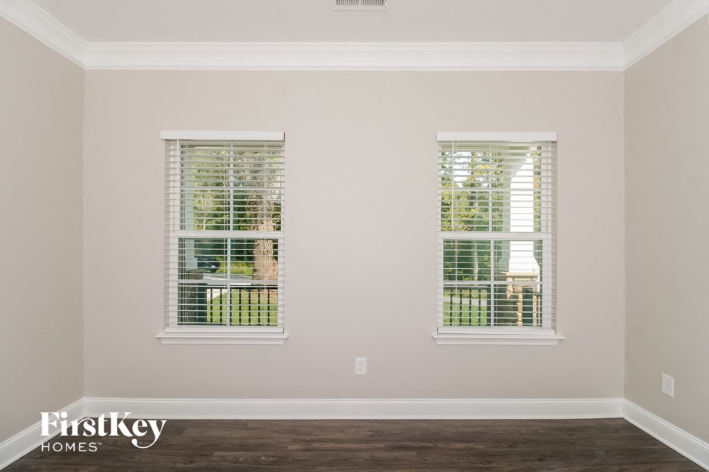 a living room with two windows and a wooden floor