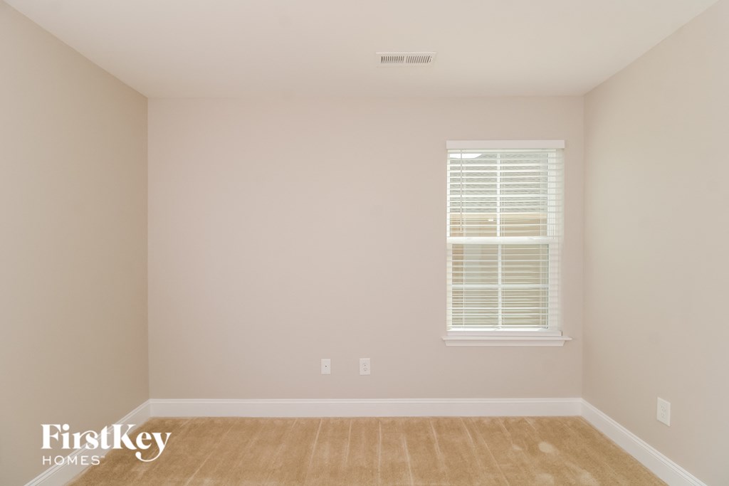a room with white walls and a window and a wooden floor