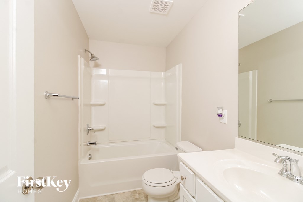 a white bathroom with a toilet and a tub and a sink