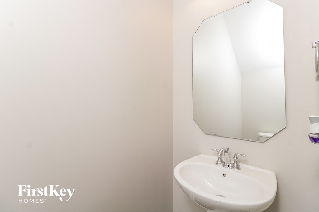 a small white bathroom with a sink and a mirror