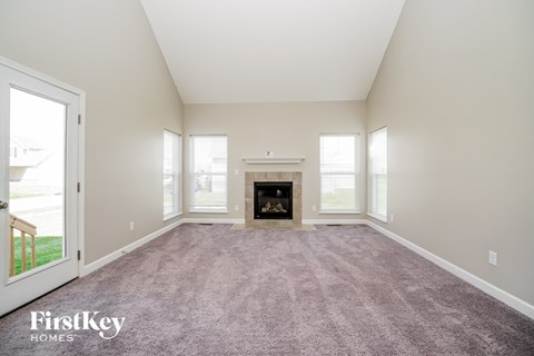 A large, empty room with a fireplace in the middle.