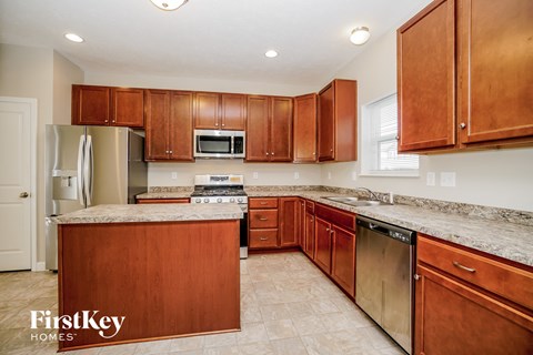A kitchen with wooden cabinets and a granite countertop.