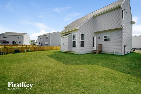 A FirstKey Homes sign is on a house in a grassy yard.