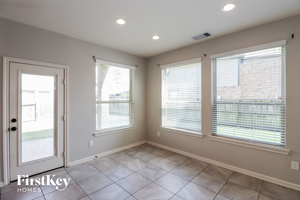 an empty room with three windows and a door