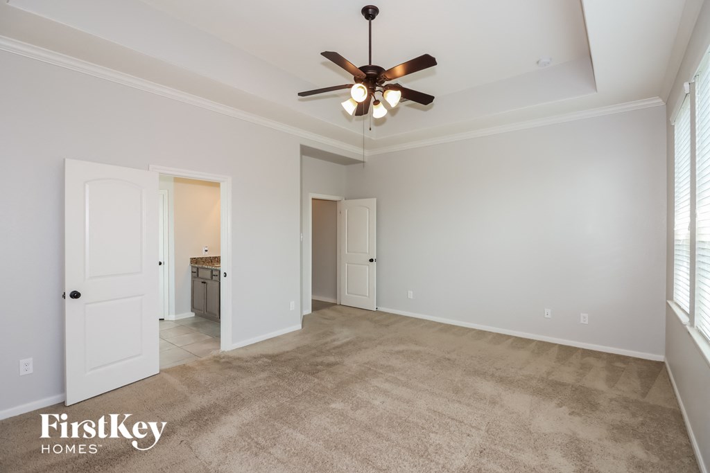 a living room with carpet and a ceiling fan