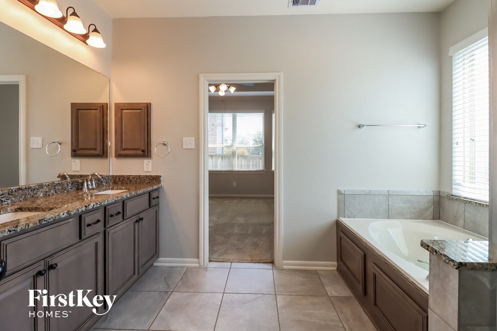 a bathroom with a tub and a sink and a mirror