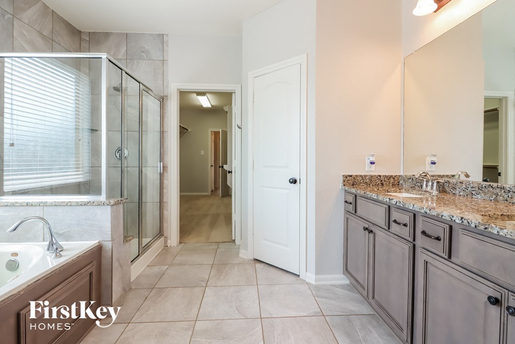 the master bathroom has a large walk in shower and dual sinks