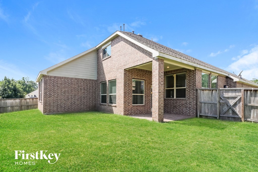 a brick house with a yard and a wooden fence