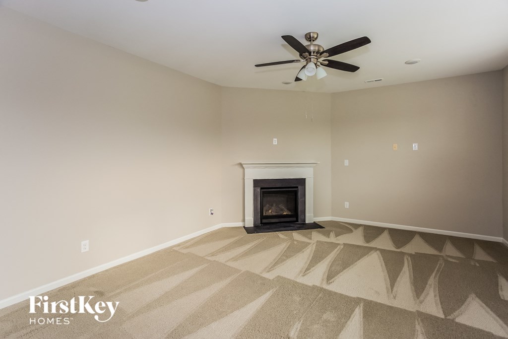 a living room with a fireplace and a ceiling fan