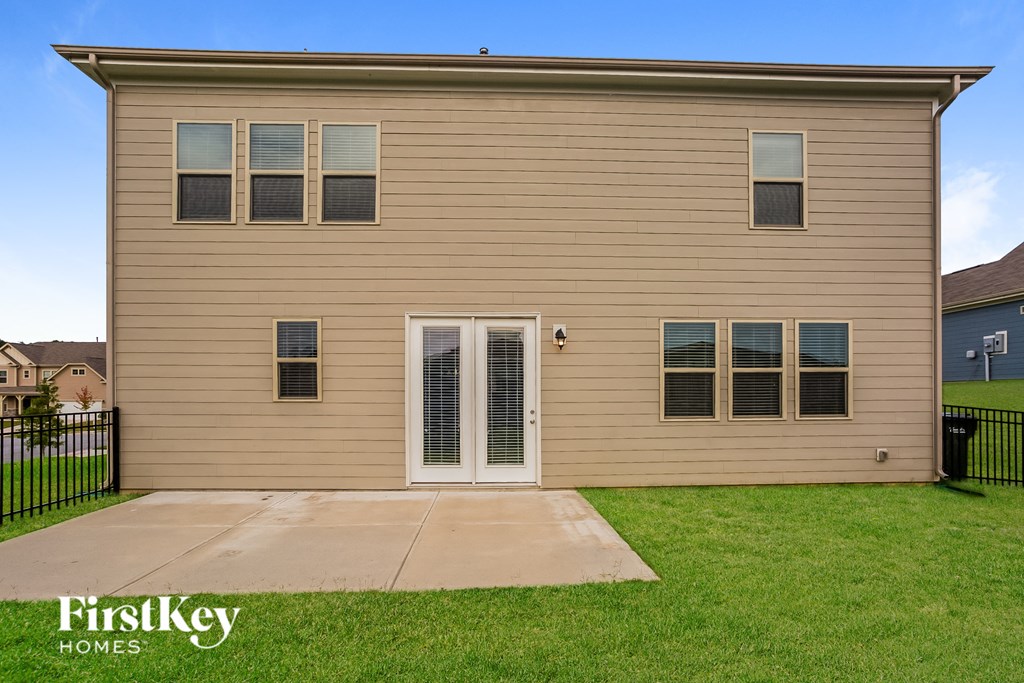 a beige home with a sidewalk and grass