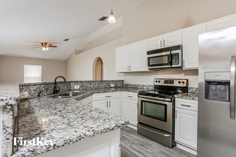 a kitchen with granite counter tops and stainless steel appliances