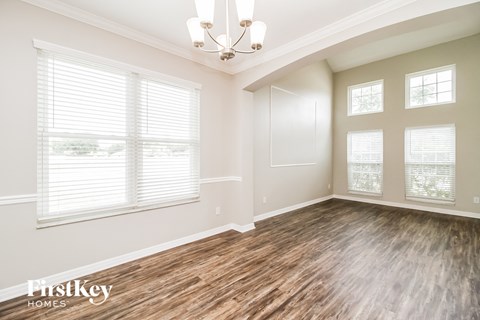 the living room of a new home with wood flooring and windows