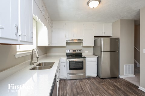 A kitchen with white cabinets and stainless steel appliances.