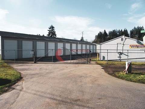 A large industrial building with a red and white sign on the side.