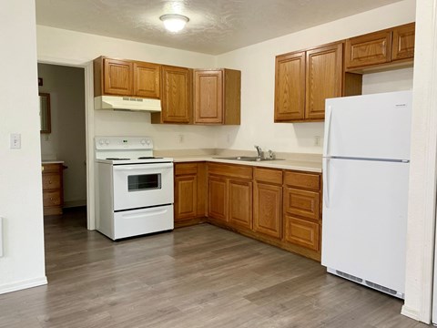 A kitchen with wooden cabinets and white appliances.