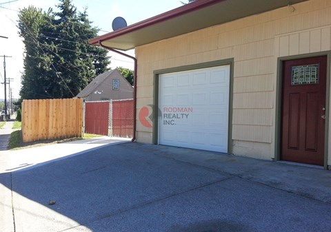 A building with a sign that says "Brody Realty Inc." on the garage door.