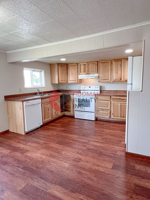 A kitchen with wooden cabinets and a refrigerator.