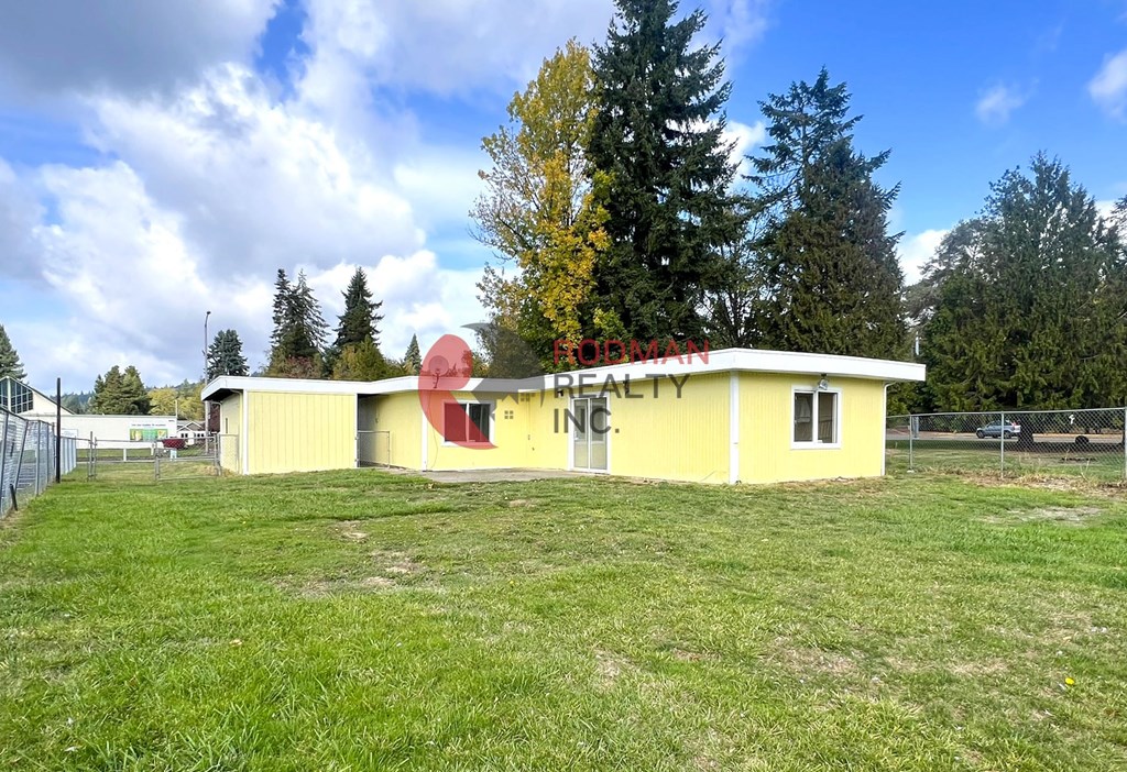 A small yellow building with a red roof and the words "BRODMAN FARM" on it.