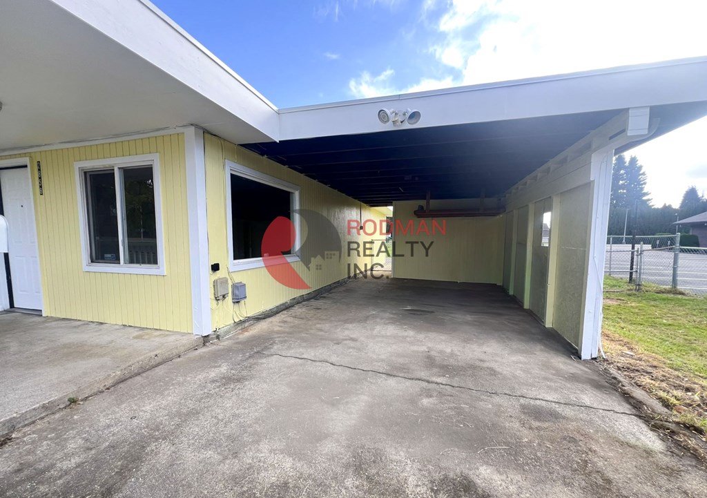 A building with a yellow exterior and a sign that reads "Brookman Realty Inc." is shown.