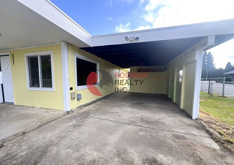 A building with a yellow exterior and a sign that reads "Brookman Realty Inc." is shown.
