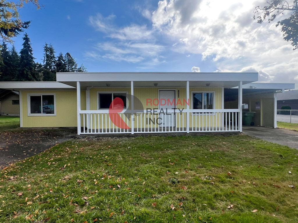 A real estate sign is displayed on the front of a house.