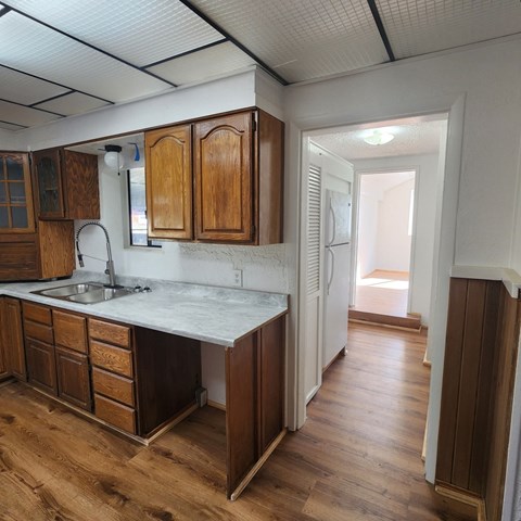 A kitchen with wooden cabinets and a marble countertop.