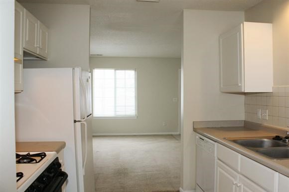 an empty kitchen with a stove and a refrigerator