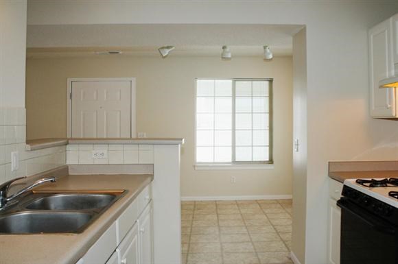 an empty kitchen with a sink and a stove