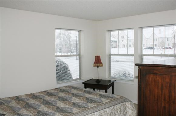 a bedroom with a bed and three windows