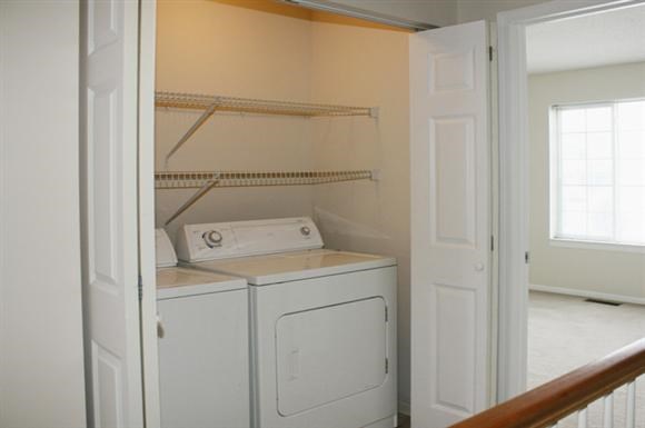 a white washer and dryer in a room with a door