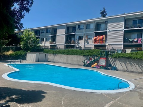 A blue swimming pool in front of a building.