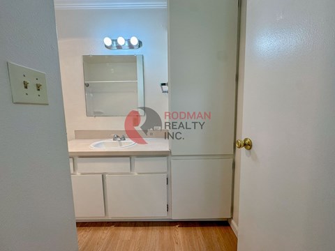 A white bathroom with a sink and mirror.