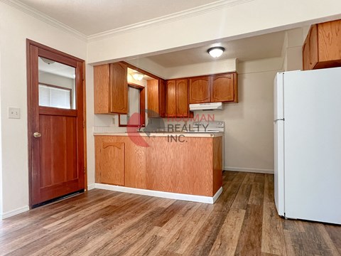 A kitchen with wooden cabinets and a white refrigerator.