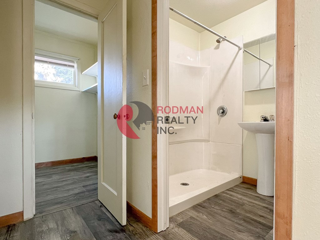 A bathroom with a walk-in shower and a window.