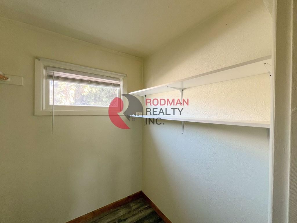 A room with a window and a sign that says Rodman Realty Inc.
