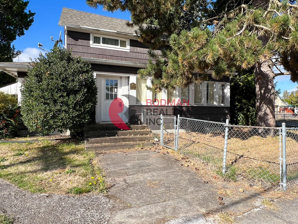 A house with a red door and a sign that says "Brodman Realty".