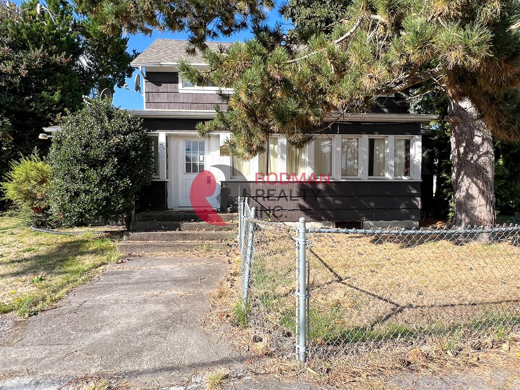 A house with a sign that says "REAL ESTATE" in front of it.