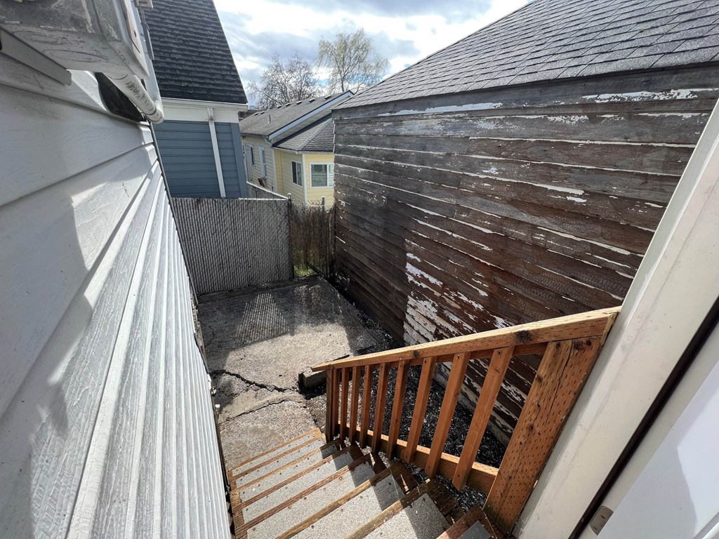 a view of the back of a house with a wooden deck