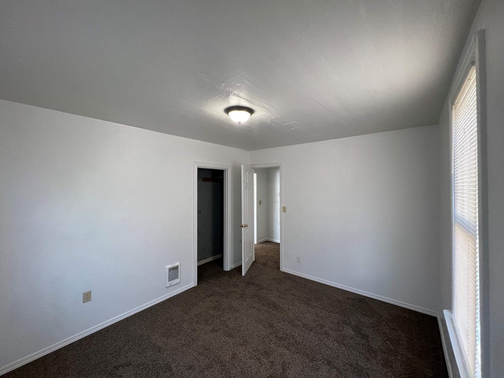 an empty living room with white walls and a carpet