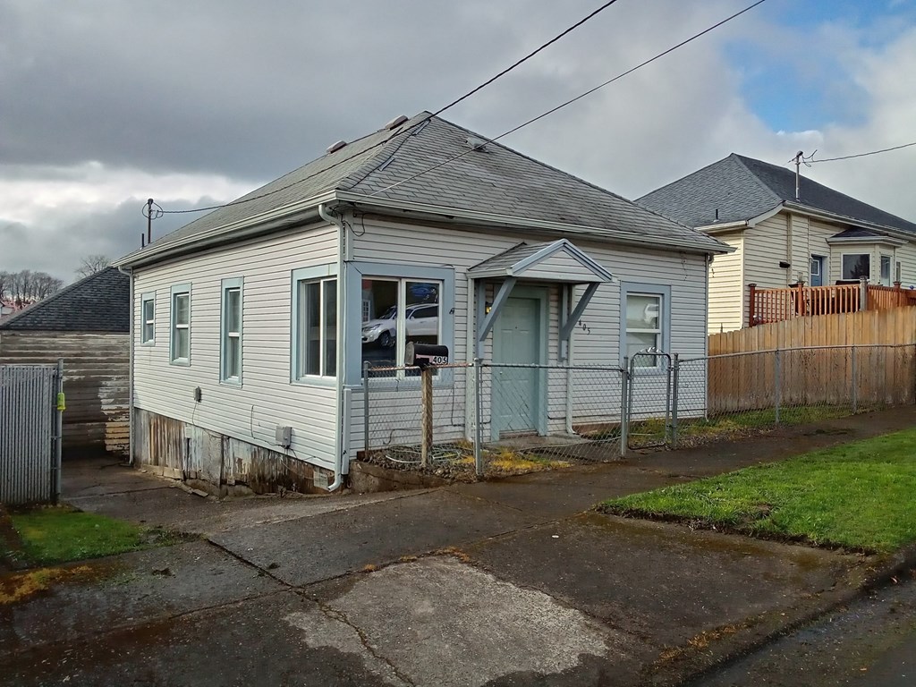 a small white house with a fence in front of it