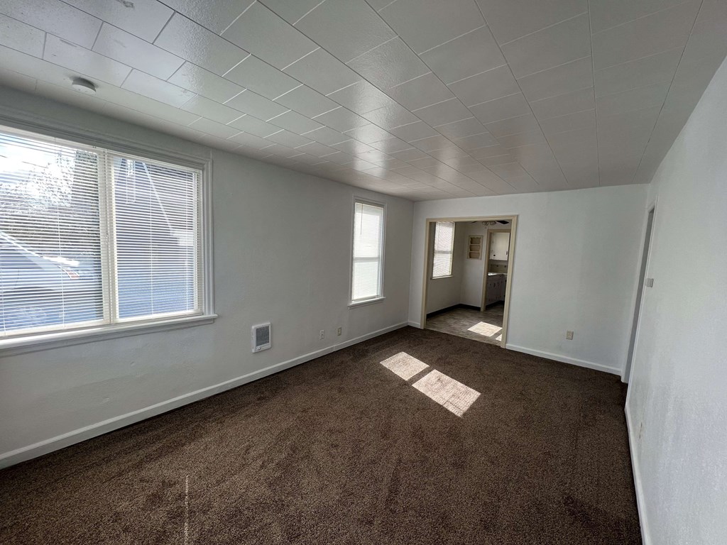 the living room of an empty house with a large window