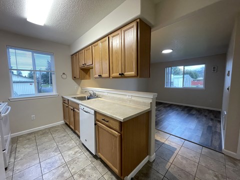 A kitchen with wooden cabinets and a white dishwasher.